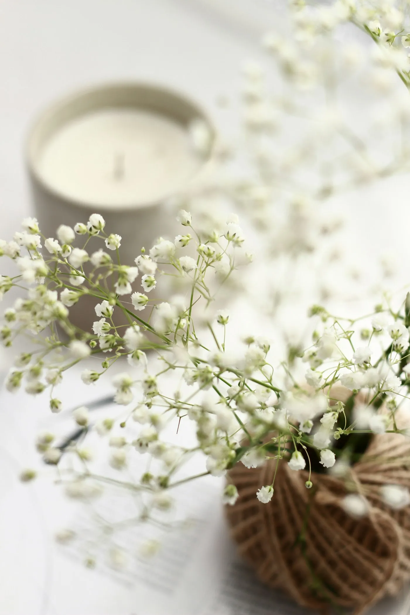 Bougie parfumée et bouquet de gypsophile dans une lumière douce
